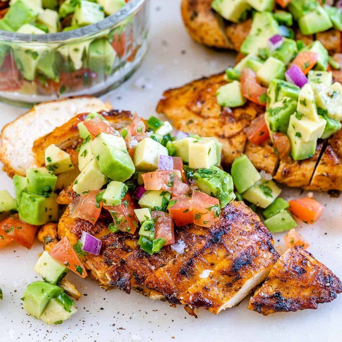 Um peito de frango grelhado com toque brasileiro, coberto por uma salsa de avocado fresca e verde