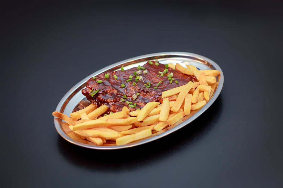 Porção de batatas fritas douradas e crocantes dispostas sobre papel absorvente ao lado de um bowl com sal marinho