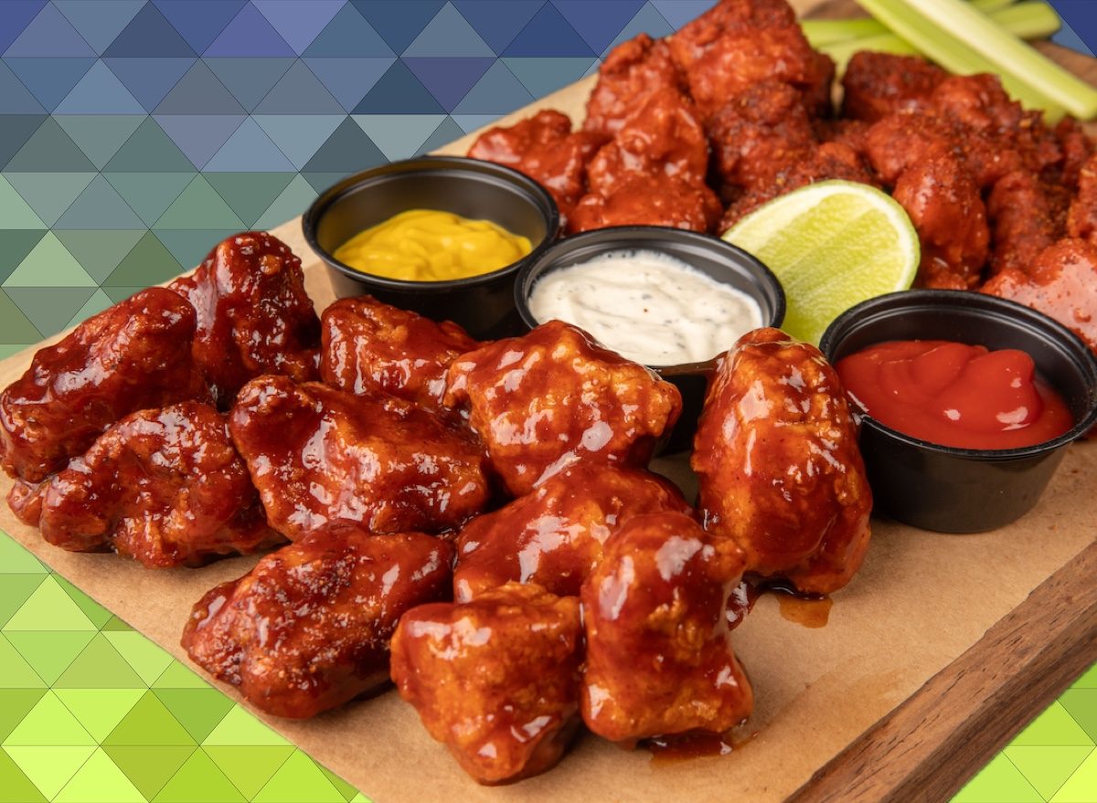 Um prato de boneless wings com molho de barbecue e legumes frescos ao lado