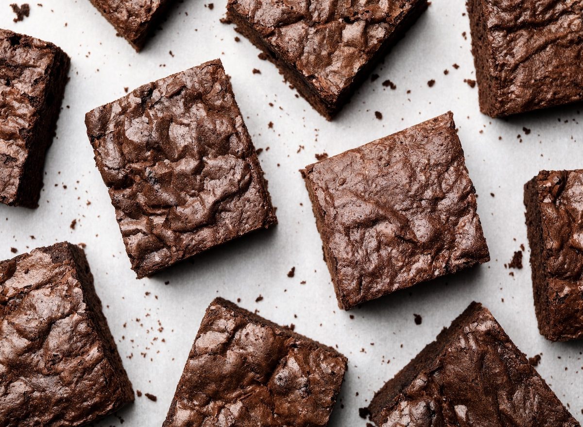 Um brownie caseiro recém-saído do forno, com textura fofa e cobertura de cacau em pó