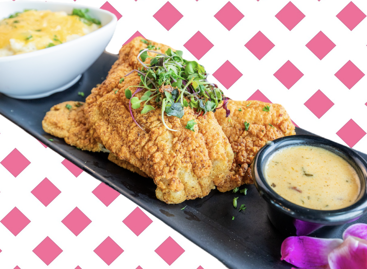 Filé de catfish empanado dourado ao lado de quinoa, brócolis e um copo de água, sobre um tapete de yoga