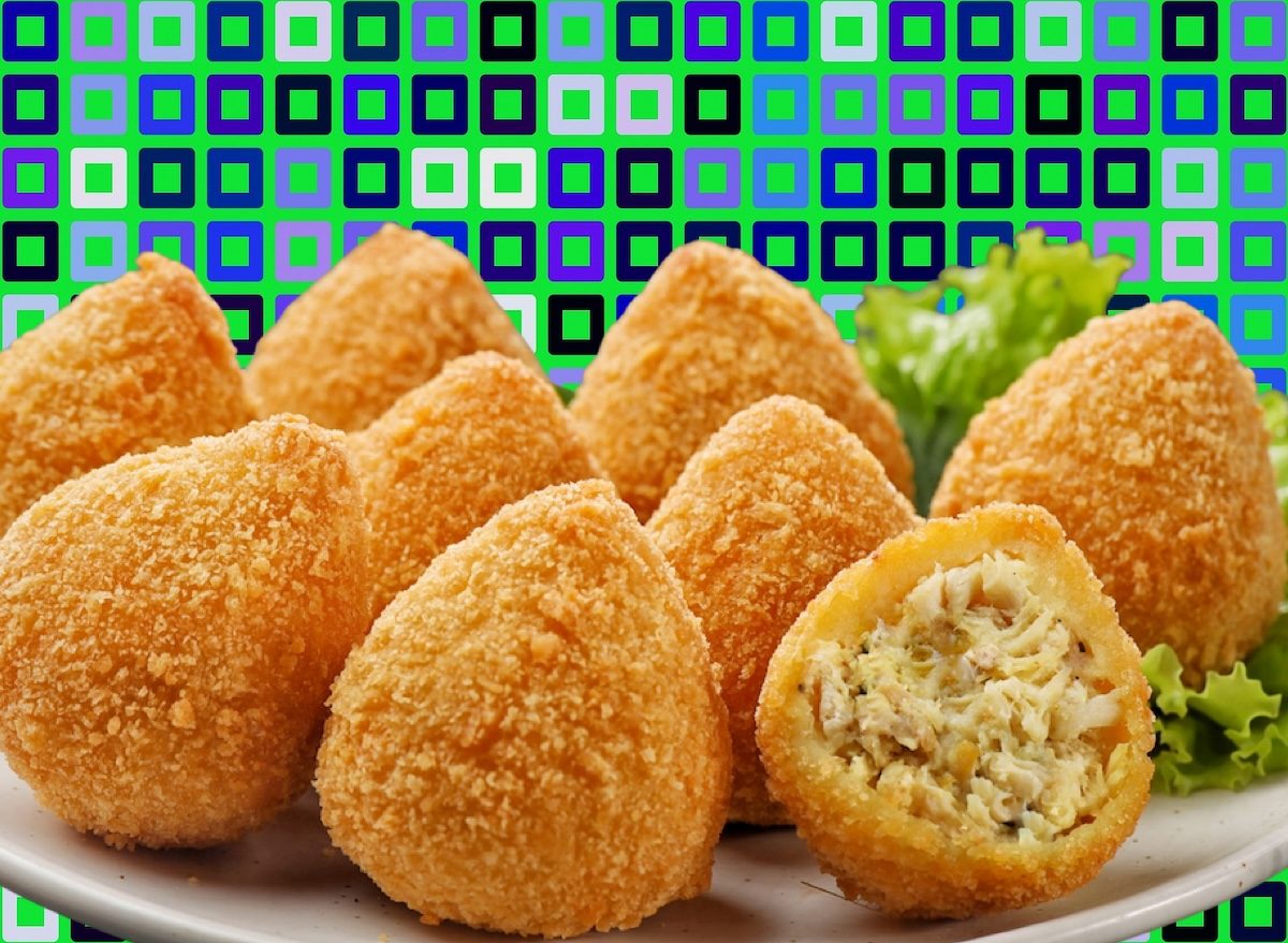 Uma croquete de frango ideal, com crocante exterior e interior cremoso, servida em um prato com folhas de alface fresca