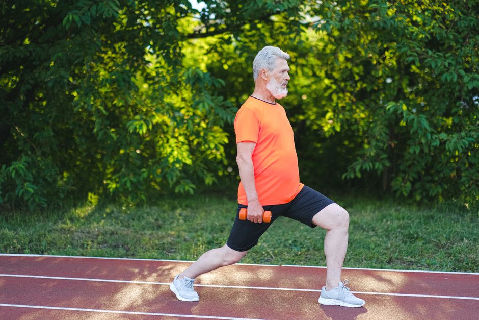 Pessoa em posição de squat, com peito erguido e olhar à frente, realizando exercício de força muscular completo