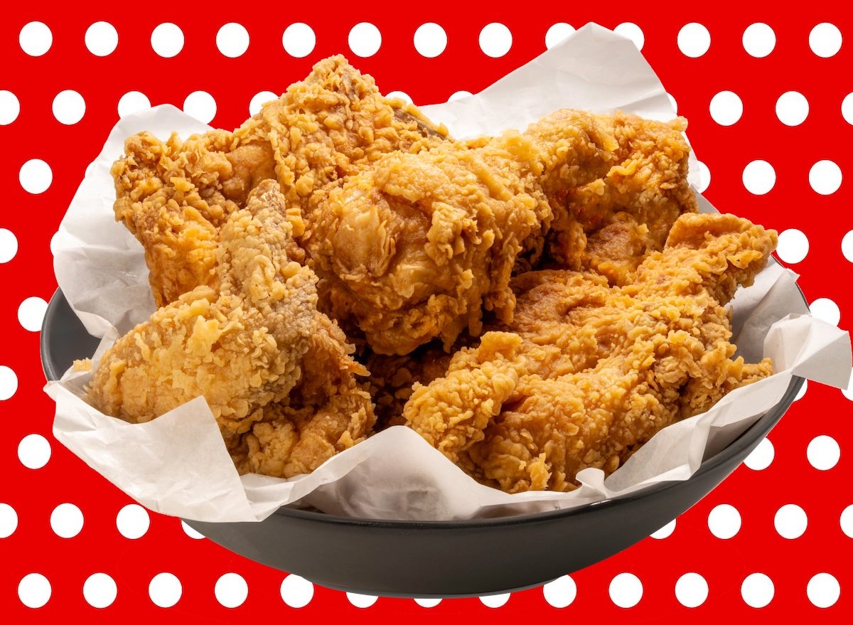 Um frango frito crocante é ilustrado com uma fatia de frango frito dourado, servido em um prato com batata palha e legumes