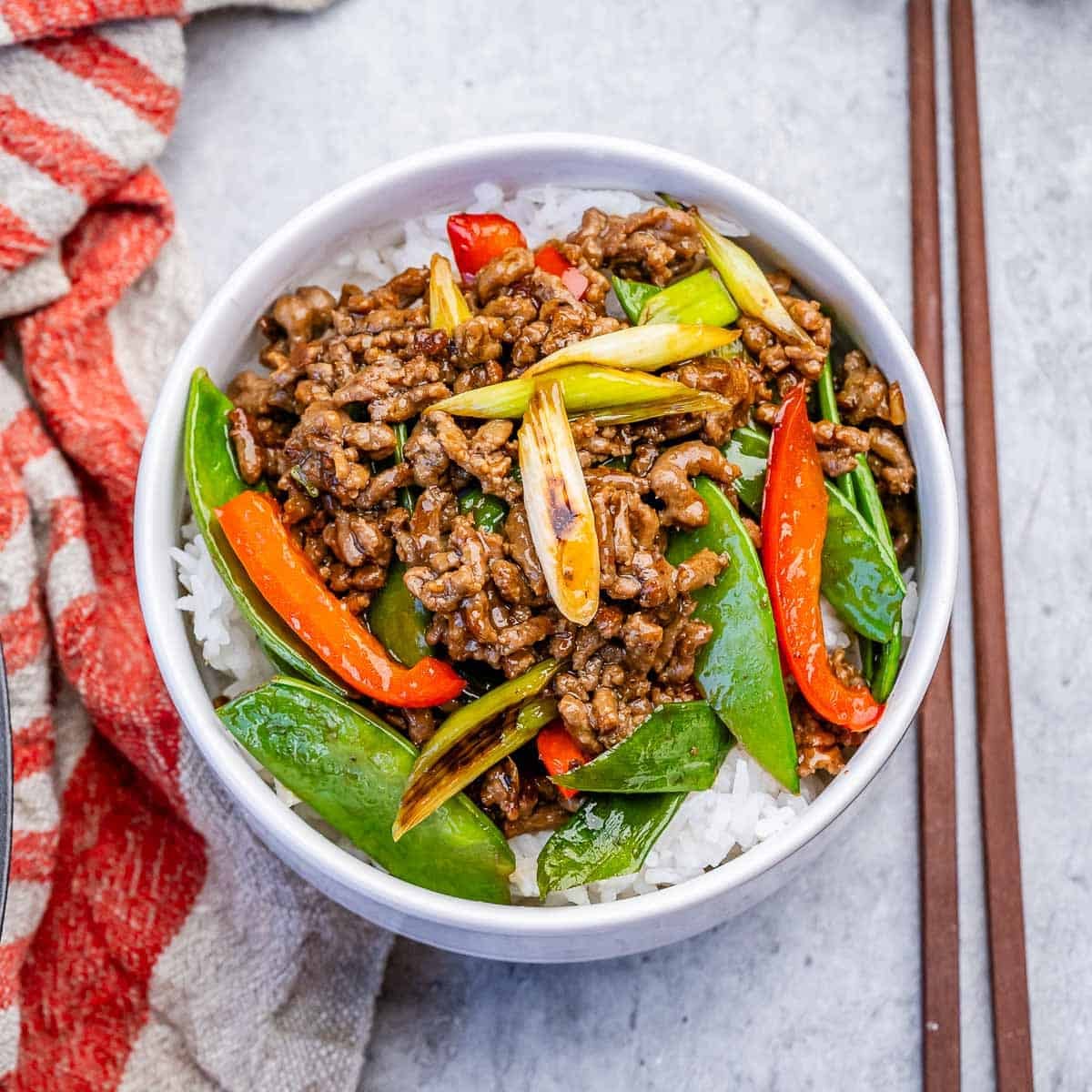 Carne moída magra e legumes frescos em uma assadeira, com molho caseiro derramado por cima