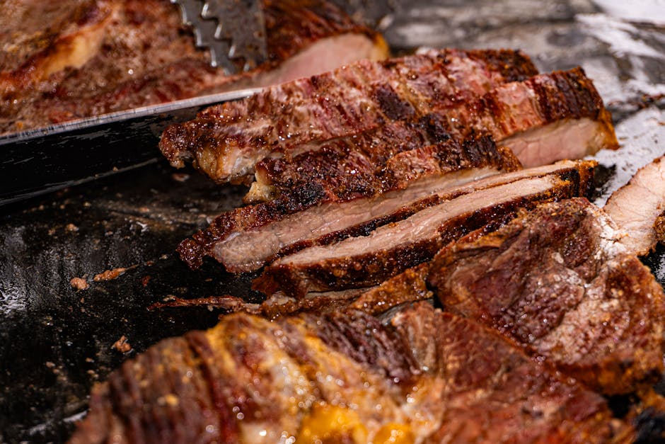 Hambúrguer de carne magra grelhado ao lado de folhas de rúcula, tomate cereja e uma tábua de corte com faca