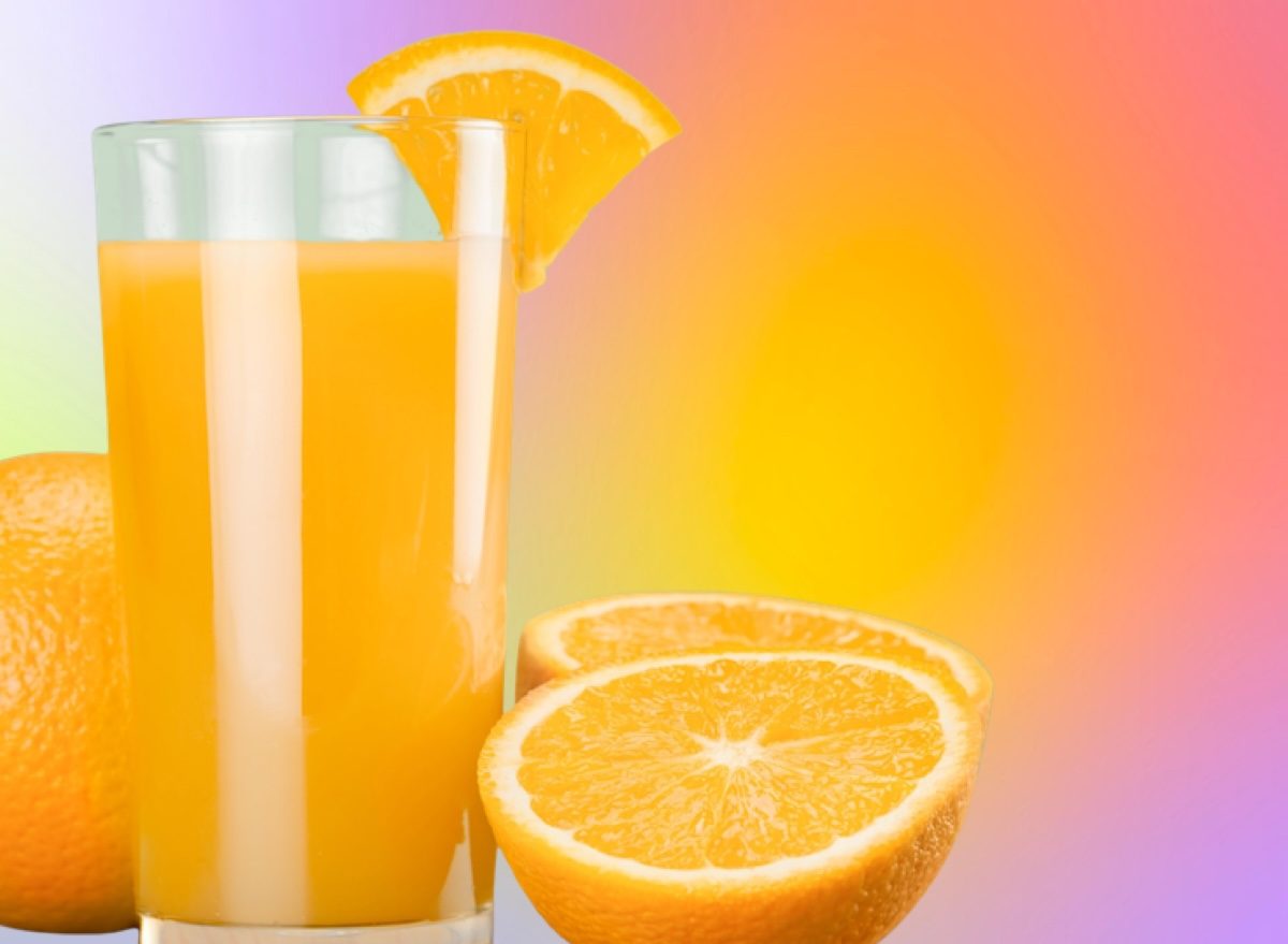 Uma garrafa de suco de laranja fresco e um frasco de suco de laranja natural são dispostos sobre uma mesa de madeira
