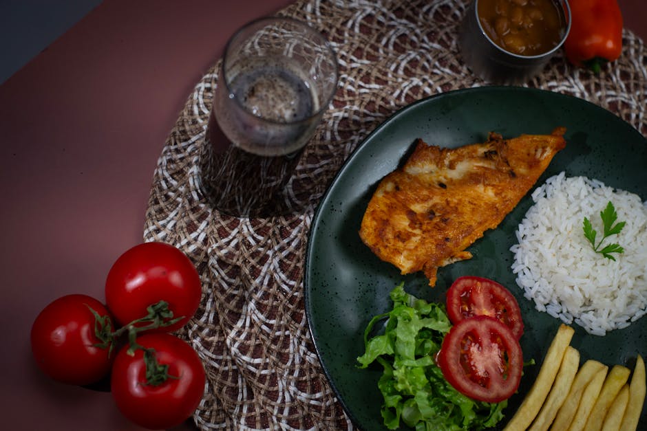 Uma placa de frango grelhado e legumes frescos, como brócolis e cenoura, sobre uma superfície de madeira