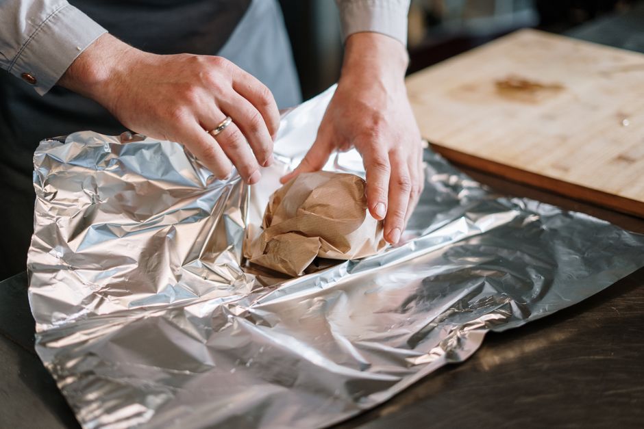 Prato com filés de salmão congelado ao lado de uma balança de cozinha e um copo de água mineral
