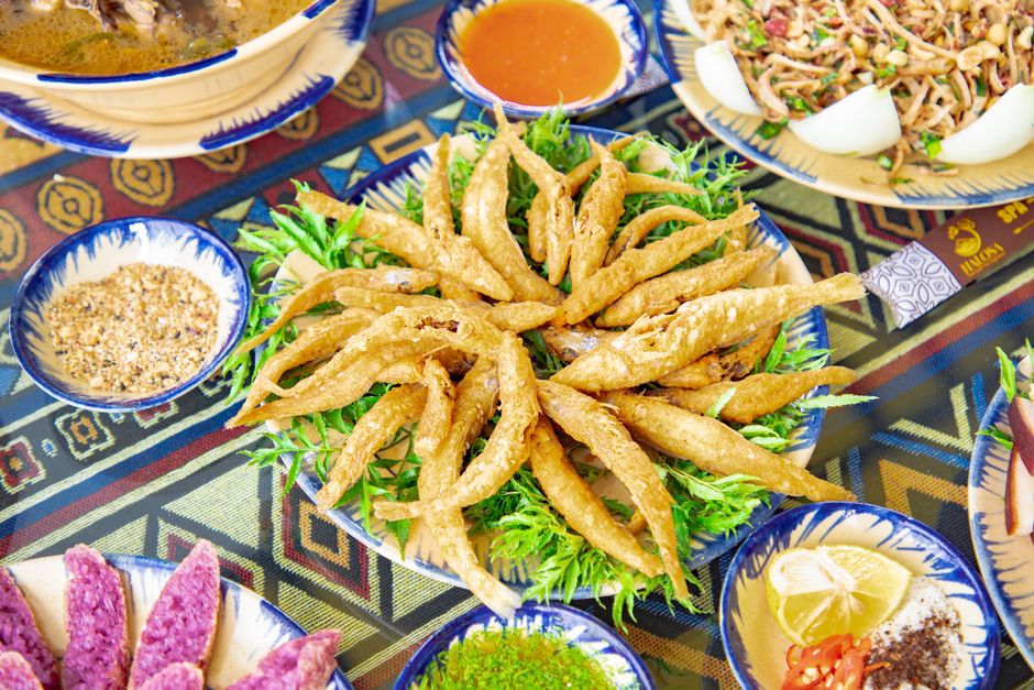 Prato com filé de peixe frito dourado ao lado de salada verde, limão e garfo, sugerindo escolha saudável
