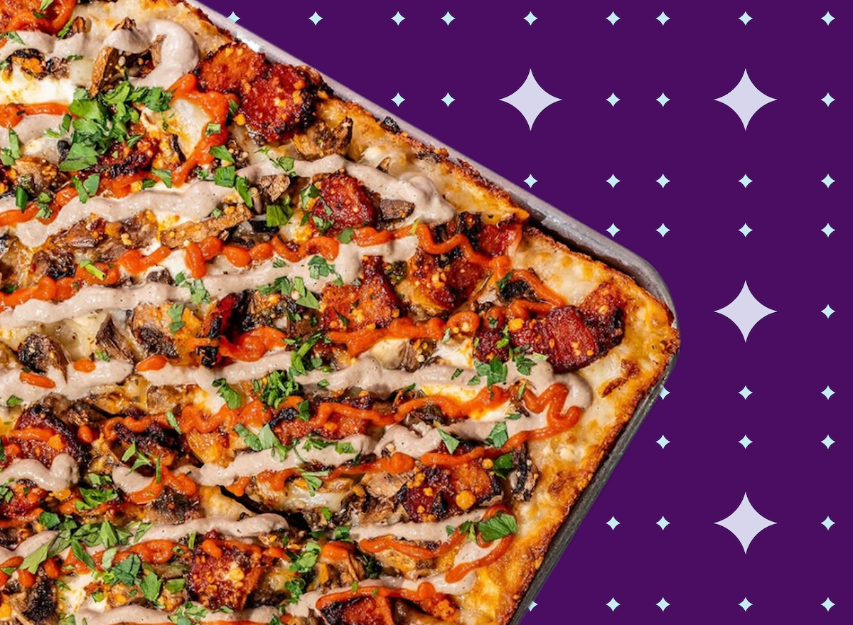 Fatia de pizza Detroit com borda crocante, queijo derretido, pepperoni e pimentões, ao lado de garrafa d'água