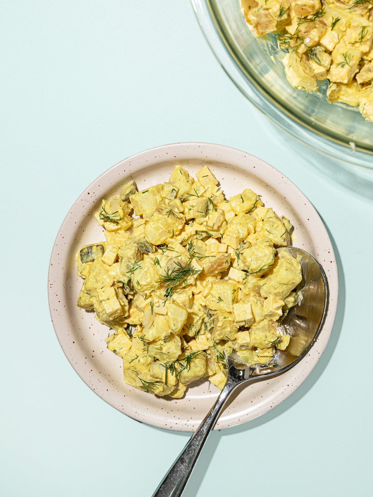 Salada cremosa de batata roxa com cubos dourados de tofu, temperada com salsinha e sementes de girassol