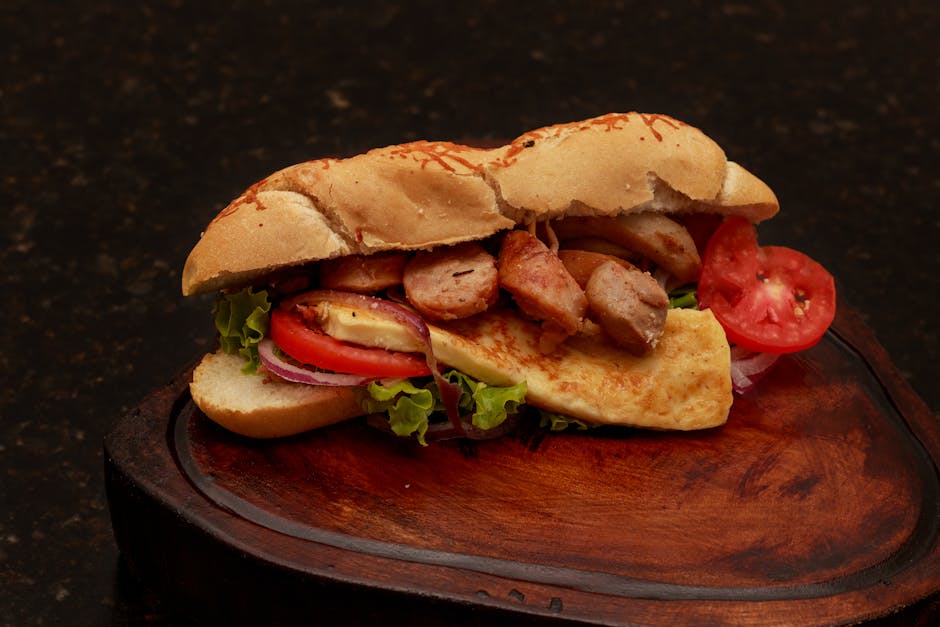 Sanduíche de peixe grelhado em pão integral com salada fresca e uma porção de vegetais ao lado em prato de cerâmica