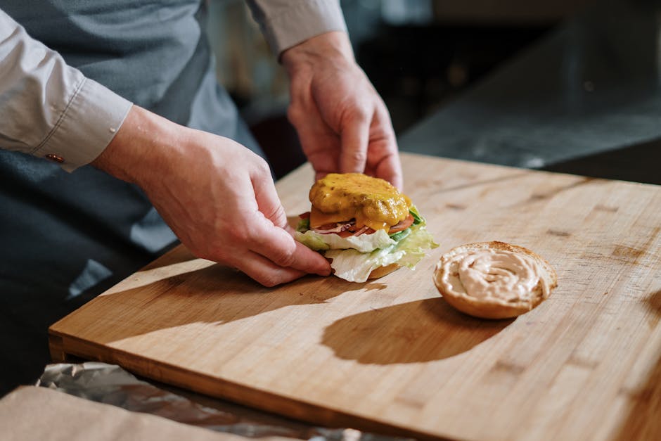 Sanduíche Sloppy Joe suculento em um prato rústico, acompanhado de talheres e ingredientes frescos sobre uma mesa