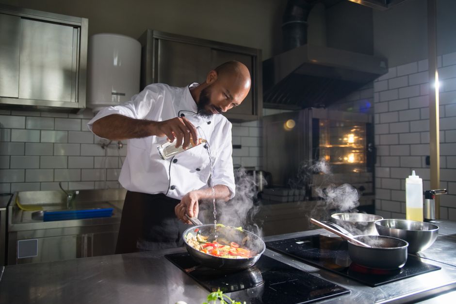 Um steak cozido no método sous vide, com crosta dourada e ponta médio-rara, em um prato à lado de uma frigideira de ferro