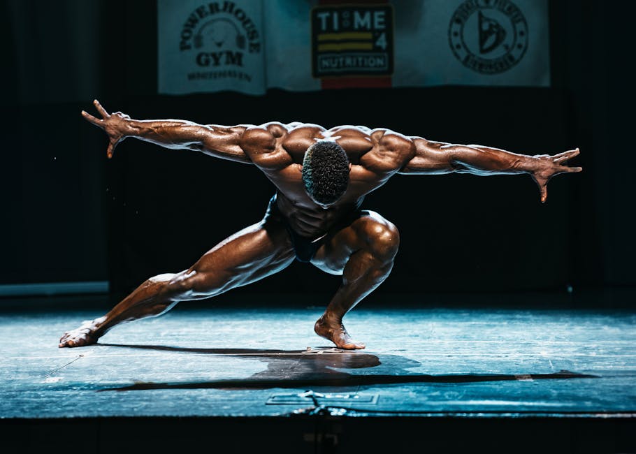 Tonio Burton posando em um palco de fisiculturismo, exibindo musculatura definida, simetria e foco total no físico