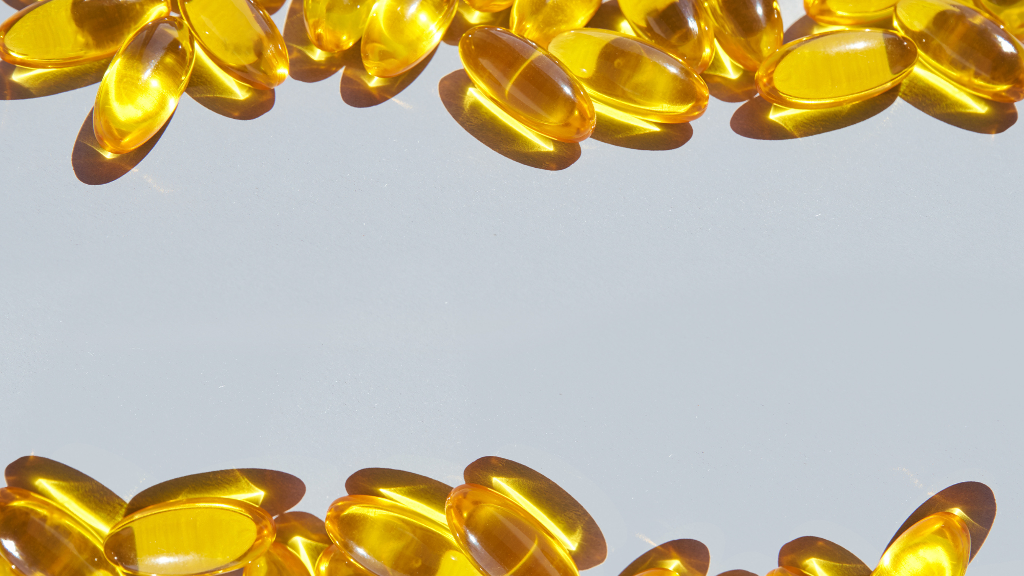 Mulher de 55 anos fazendo alongamento, ao lado de cápsulas de vitamina B12 e frutas verdes